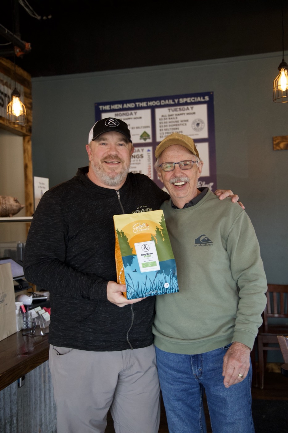 Jeff, Ember's Business Growth Coach, with Matt Taus of The Hen & The Hog holding an Ember Hog Roast bag